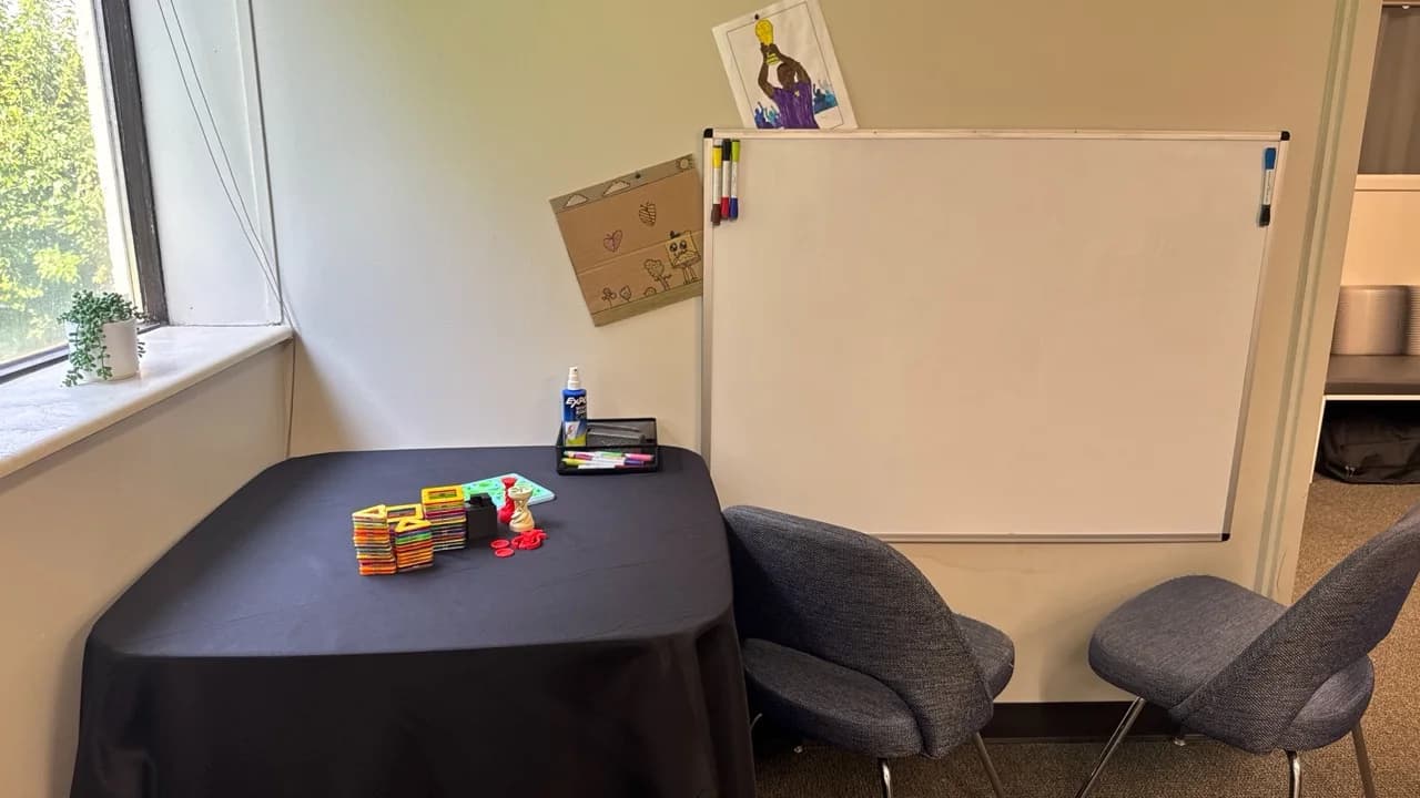 Family activity area with a table and whiteboard at Advanced Wellness Chiropractic